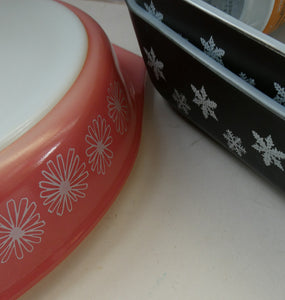 Two 1950s Vintage PYREX GAEITY Serving Dishes. One Oval Pink with Daisy Pattern. One Oblong Black Dish with Snowflake Pattern