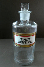 Load image into Gallery viewer, Larger Antique Clear Glass Chemist Bottle. TINCT: CENT: CO: with Original Foil Label and Lozenge Stopper
