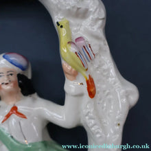 Load image into Gallery viewer, ANTIQUE Victorian 1880s Staffordshire Figurine. Courting Couple Sitting Underneath the Arch of a Bough Holding a Yellow Bird
