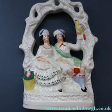 Load image into Gallery viewer, ANTIQUE Victorian 1880s Staffordshire Figurine. Courting Couple Sitting Underneath the Arch of a Bough Holding a Yellow Bird
