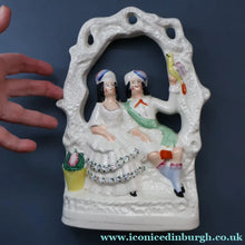 Load image into Gallery viewer, ANTIQUE Victorian 1880s Staffordshire Figurine. Courting Couple Sitting Underneath the Arch of a Bough Holding a Yellow Bird
