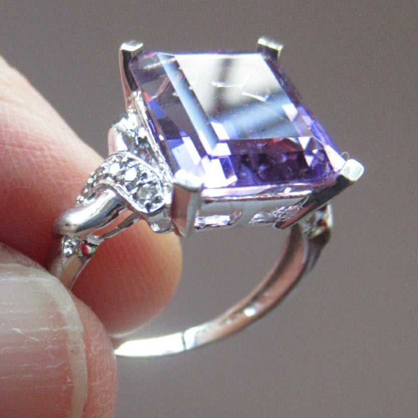 Pretty 9 CT White Gold Ring Set with an Emerald Cut Amethyst & flanked with decorative diamond chips. Size N 1/2