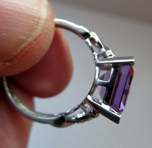 Pretty 9 CT White Gold Ring Set with an Emerald Cut Amethyst & flanked with decorative diamond chips. Size N 1/2