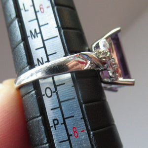Pretty 9 CT White Gold Ring Set with an Emerald Cut Amethyst & flanked with decorative diamond chips. Size N 1/2