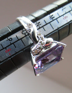 Pretty 9 CT White Gold Ring Set with an Emerald Cut Amethyst & flanked with decorative diamond chips. Size N 1/2