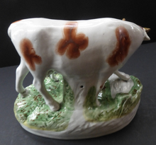 Load image into Gallery viewer, ANTIQUE STAFFORDSHIRE Figurine. Large Cow with her White Calf on Raised Oval Base; 1880s
